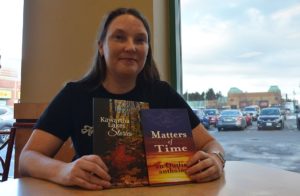 Sara C. Walker poses with her two latest books